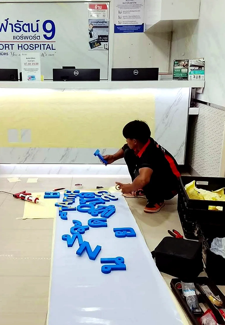 ทีมงานติดตั้งตัวอักษรป้ายภายในอาคาร